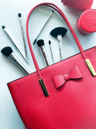 Red Bag with Mirabella Beauty Makeup Brushes & Case on white background