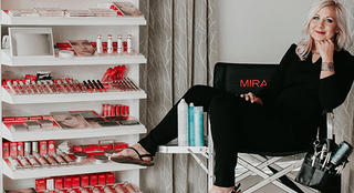 Salon professional sitting next to organized Mirabella Mini Open Display of beauty products and tools in a sanitized salon environment, emphasizing cleanliness and hygiene in post-pandemic beauty care.