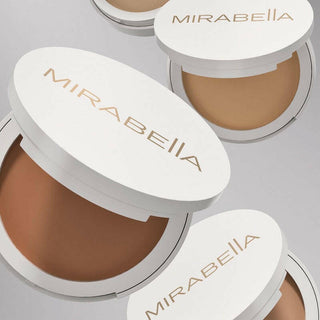 Mirabella Invincible for All Pure Press compacts opened to showcase the diverse shade offerings for all skin tones on a gray background. 